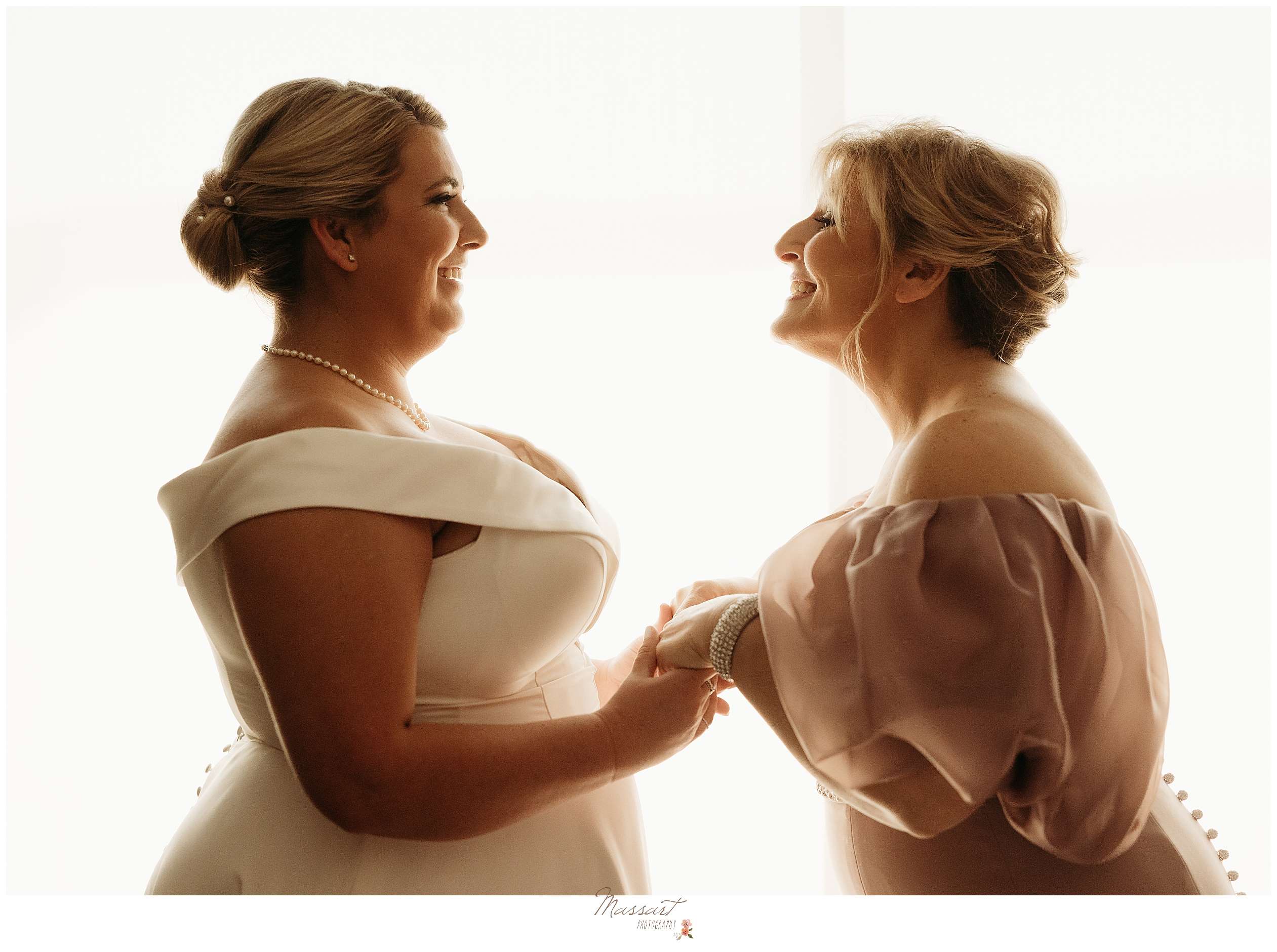 bride and mom grin smiling at each other during prep for Rhode Island wedding day