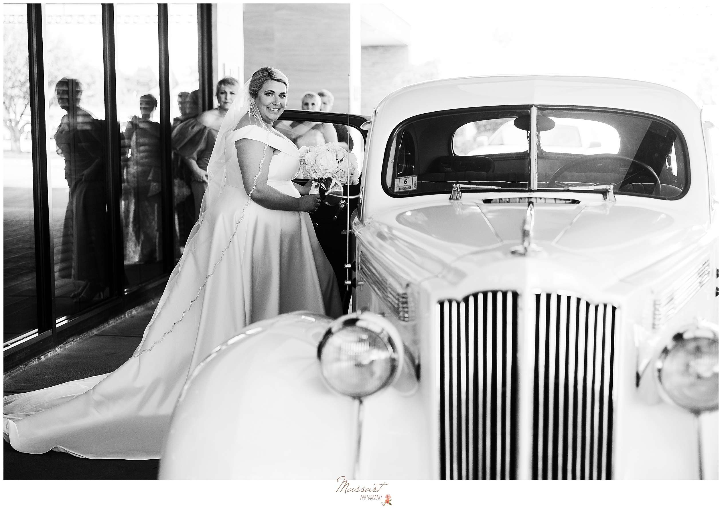 bride climbs into white Rolls Royce on wedding day outside hotel