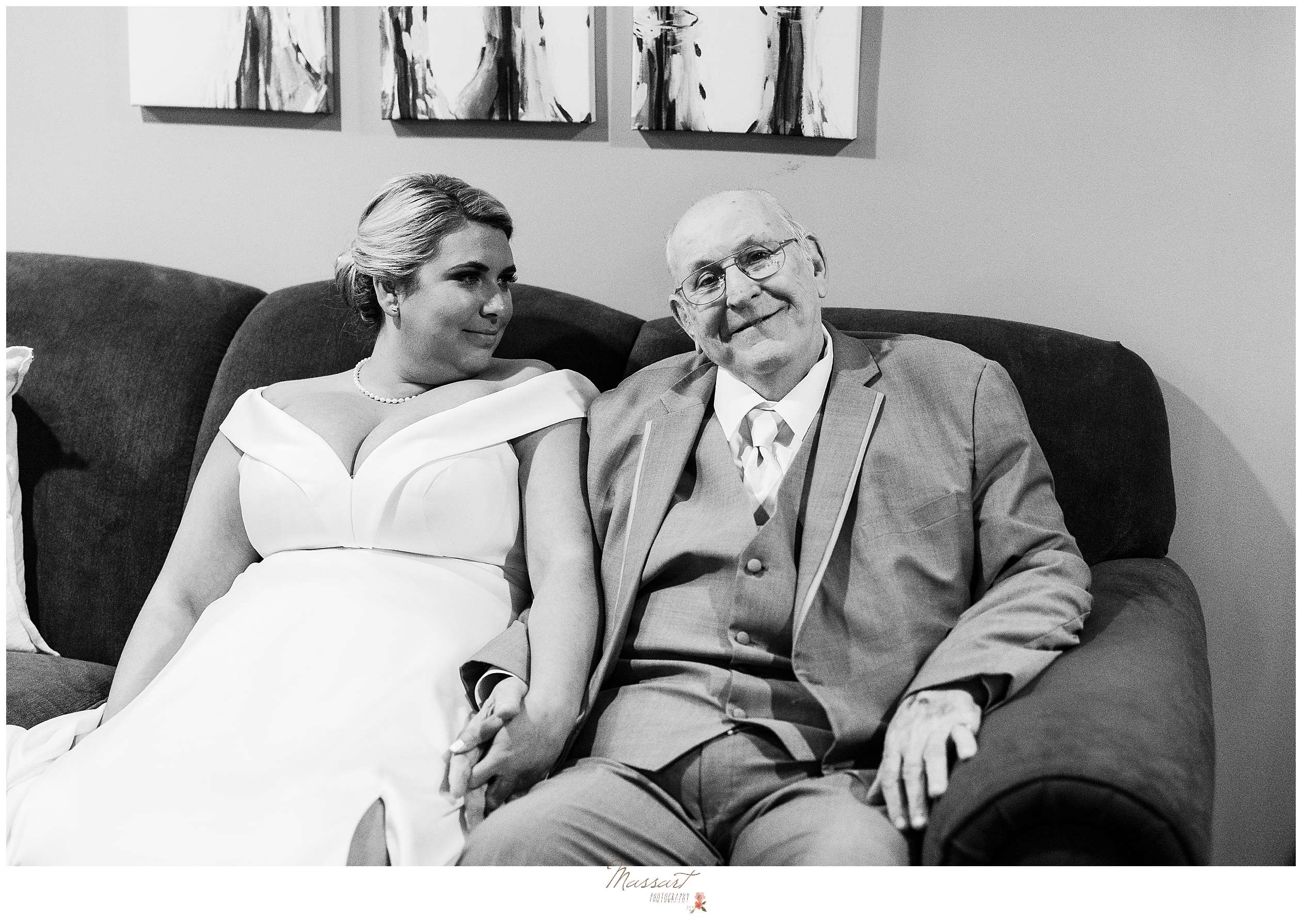 bride sits on sofa holding father's hand during Rhode Island wedding day prep