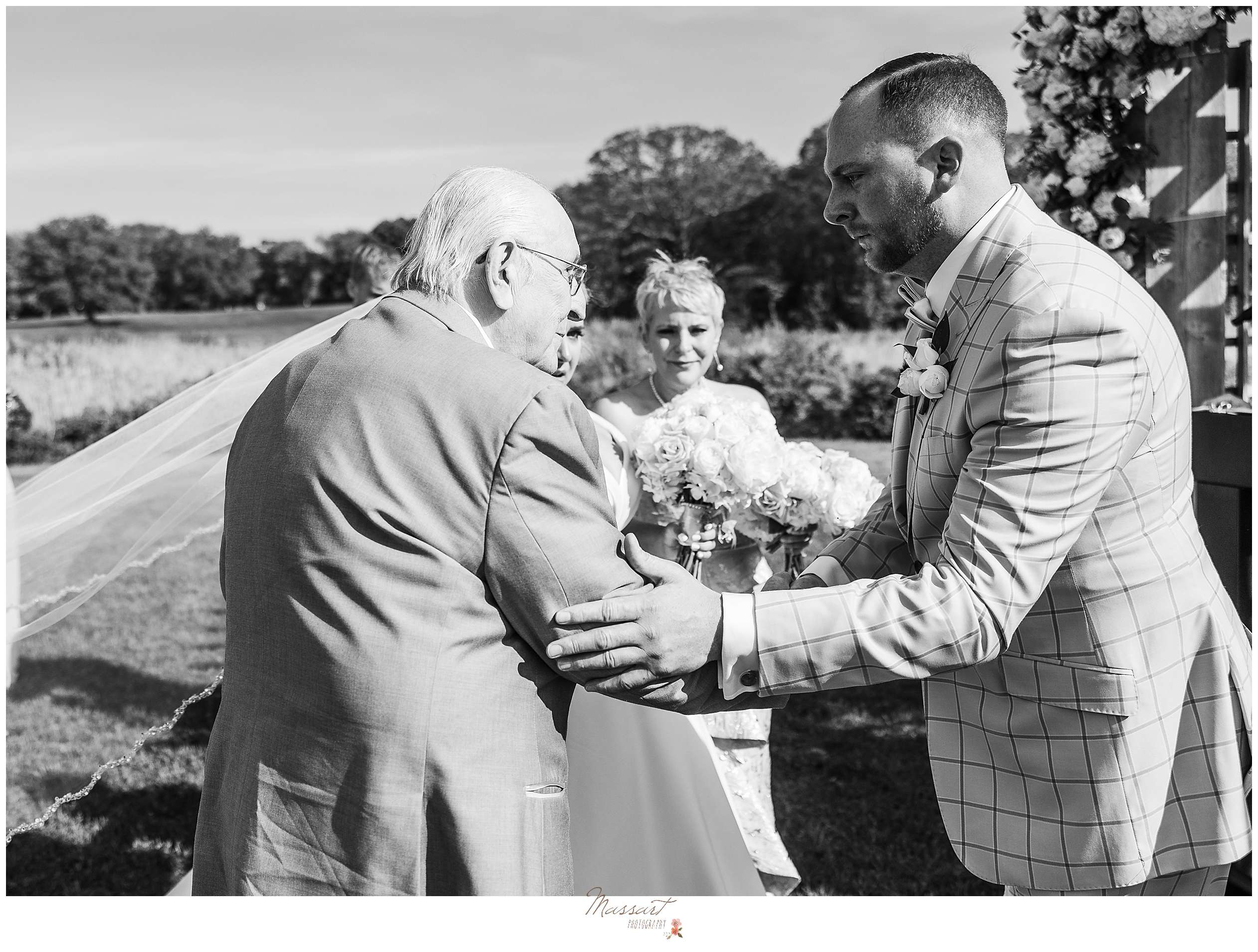 groom shakes older man's hand during wedding ceremony
