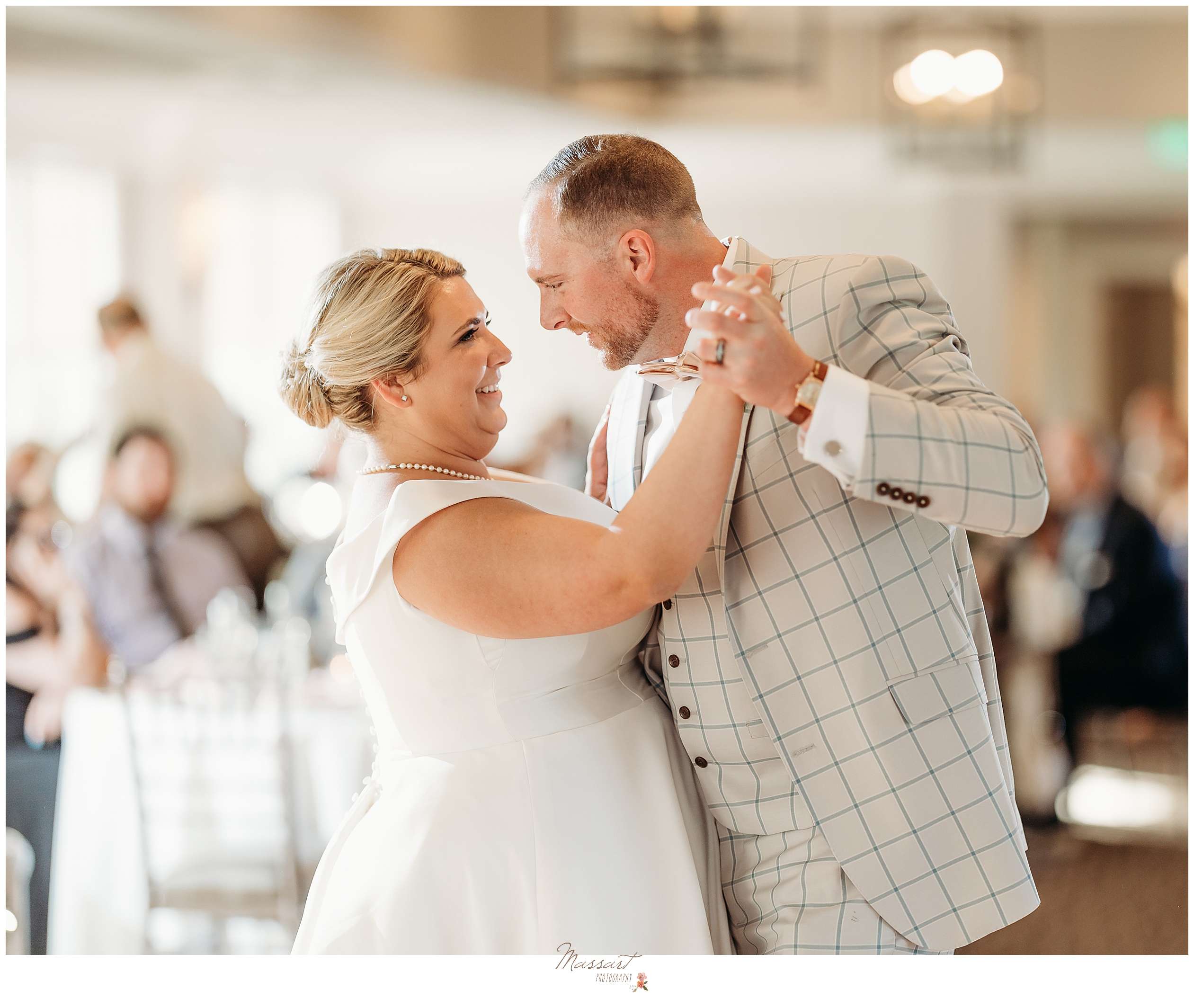 newlyweds grin during first dance at Harbor Lights wedding reception