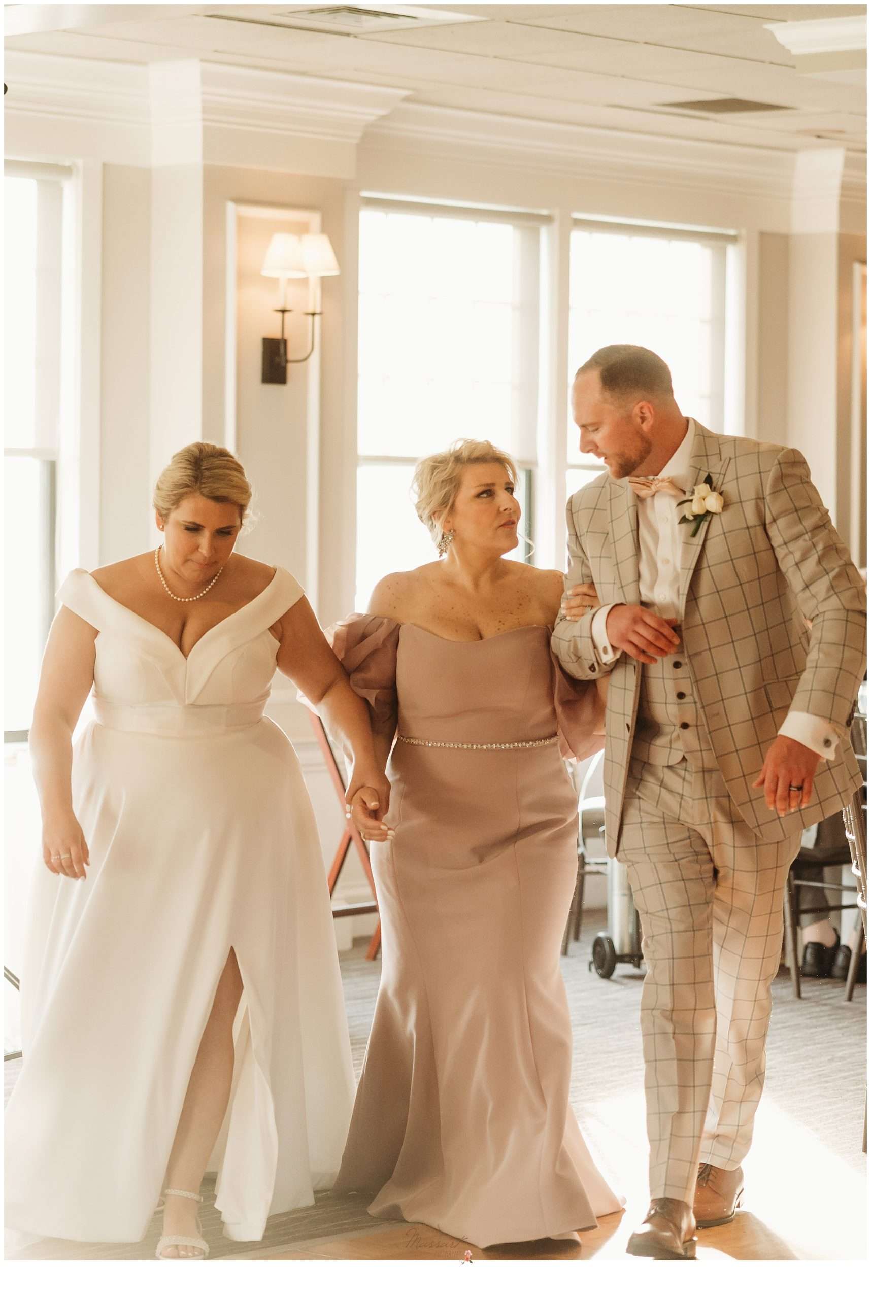 bride and groom escort mother of the bride into Harbor Lights wedding reception